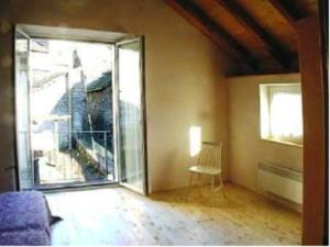 ein Wohnzimmer mit einem großen Fenster und einem Stuhl in der Unterkunft Casa Elin in Maggia