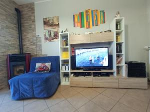a living room with a tv and a blue couch at House 39 in Capranica