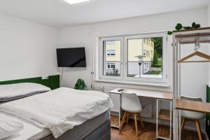 a bedroom with a bed and a desk and a window at Geschäftsreisetraum 3SZ 5P - Waschtrockner, Balkon in Oberkochen