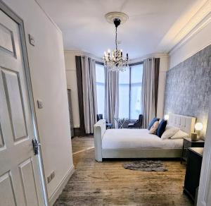 a living room with a white couch and a chandelier at INNit Marina in Brighton & Hove