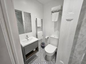 a white bathroom with a toilet and a sink at INNit Marina in Brighton & Hove
