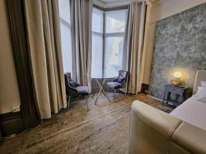 a hotel room with two chairs and a bed and a window at INNit Marina in Brighton & Hove