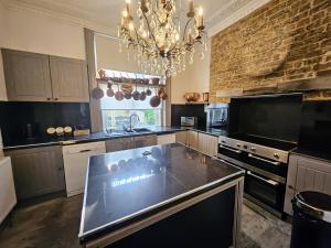 a large kitchen with a chandelier and a stone wall at INNit Marina in Brighton & Hove