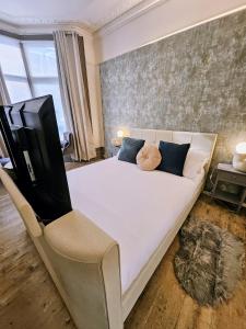 a bedroom with a large white bed and a television at INNit Marina in Brighton & Hove
