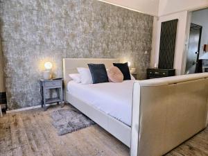 a bedroom with a large white bed and a wall at INNit Marina in Brighton & Hove