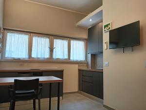 a kitchen with a table and a tv on a wall at Monocamper in Monza