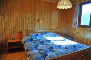 een slaapkamer met een groot bed in een houten muur bij Swaens in Heure