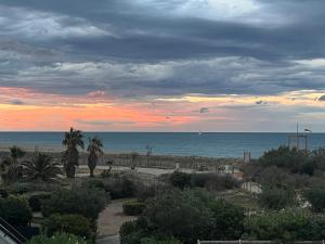 a view of the beach at sunset with the ocean at Le Panorama du Tropique Saint Cyprien - Saint-Cyprien-Plage - Perpignan 66 Vue mer - Front de mer in Saint-Cyprien