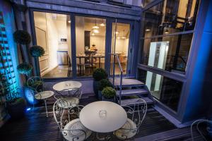 a patio with tables and chairs on a balcony at Le Mireille in Paris +37 photos