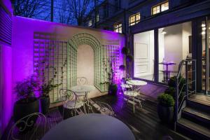a room with tables and chairs and purple lights at Le Mireille in Paris