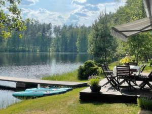 a dock with a table and chairs next to a lake at Kõverajärve saunamaja in Nedsaja