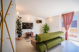 a living room with a green couch and potted plants at Bitter 26 Apartment - Vinto House Collections in Nocera Superiore