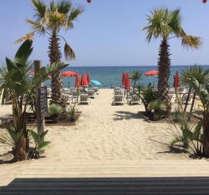 a beach with chairs and umbrellas and the ocean at Maison plage 200 mts Sainte Marie in Sainte-Marie-Plage