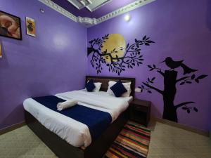a bedroom with a bed with a purple wall at MANIK GUEST HOUSE in Rishīkesh