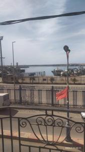 a view of the ocean from a balcony with a flag at Appartement Ghazaouet front de mer in Delmonte