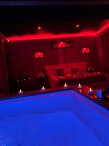 a living room with a pool and red lighting at Le Lodge des Charmes 5 étoiles in Lèves