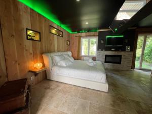 a bedroom with a white bed with green lights at Le Lodge des Charmes 5 étoiles in Lèves +59 photos
