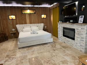a bedroom with a white bed and a fireplace at Le Lodge des Charmes 5 étoiles in Lèves