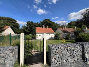 a gate to a house with a stone fence at Le Lodge des Charmes 5 étoiles in Lèves