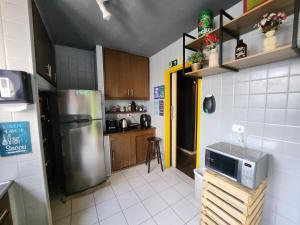 a kitchen with a stainless steel refrigerator and wooden cabinets at Vila Rock Hostel - próximo Allianz Parque, Vila Madalena, Av Paulista, Hospital das Clínicas INCOR FMUSP in São Paulo