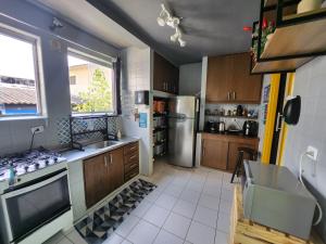 a kitchen with a stainless steel refrigerator and a sink at Vila Rock Hostel - próximo Allianz Parque, Vila Madalena, Av Paulista, Hospital das Clínicas INCOR FMUSP in São Paulo