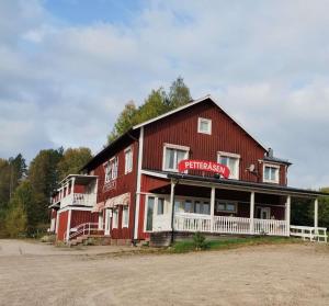 a large red building with a sign on it at Petteråsens Guest room in Torsby