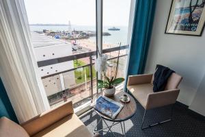 a living room with a table and chairs and a large window at Best Western Hôtel Royan Océan in Royan