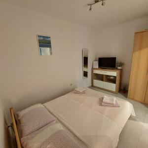 a bedroom with two beds and a television in it at Apartments Ustavdic in Korčula +50 photos