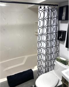a bathroom with a toilet and a bath tub at YEG Chic Luxury Accommodation in Edmonton +26 photos