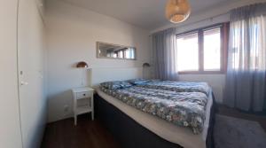 a small bedroom with a bed and a window at Elice Apartment in Rovaniemi