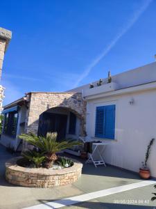 a home with a brick building with blue shutters at Tramonti d'Alba in Terrasini