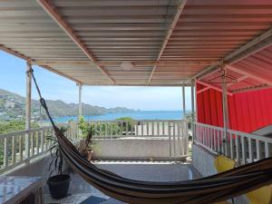 un hamac sur un porche avec vue sur l'océan dans l'établissement Magic horizont, à Taganga