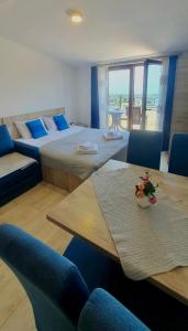 a room with two beds and a table and chairs at Mips Amadeus P85 in Cajetina