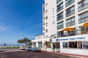 a large white building with cars parked in front of it at Best Western Hôtel Royan Océan in Royan