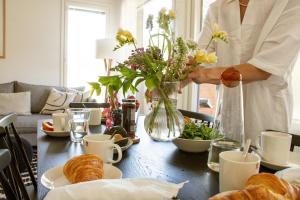 a man is arranging a table with a vase of flowers at Alppinotko HimosKoto Hosted by Hygge Host in Jämsä