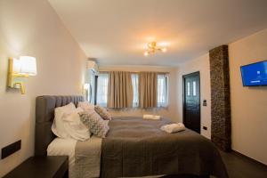 a bedroom with a bed with pillows on it at Berat River House Boutique Hotel in Berat