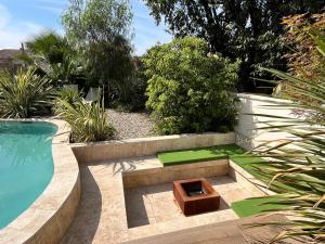 un jardin avec un banc et une piscine dans l'établissement Villas de Provence - Maison avec piscine chauffée "Oasis de Satteva", à LʼIsle-sur-la-Sorgue