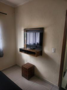 un salon avec une télévision à écran plat sur un mur dans l'établissement Casa Central, à Serra Negra