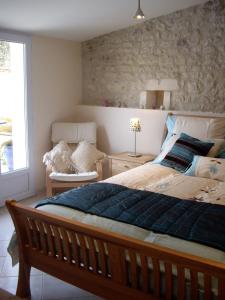 ein Schlafzimmer mit einem großen Bett und einem Fenster in der Unterkunft Maison Du Ruisseau in Malaville