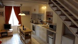 eine Küche mit einer Treppe in der Mitte einer Küche in der Unterkunft Maison Du Ruisseau in Malaville