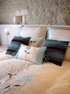 ein Bett mit mehreren Kissen darüber in der Unterkunft Maison Du Ruisseau in Malaville