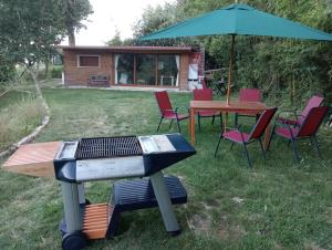 a grill with chairs and a table and an umbrella at A Corcheira in Pontevedra