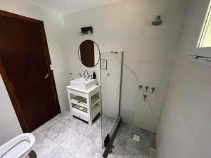 Un baño con lavabo y ducha con espejo. en Casa Leo - Casa Con pileta en Zona Acantilados Para 4 PAX - Hola Sur, en Mar del Plata 5 fotos más