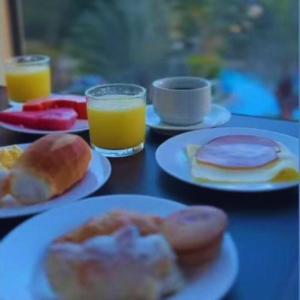 a table with plates of breakfast foods and glasses of orange juice at Águas do Paranoá in Caldas Novas
