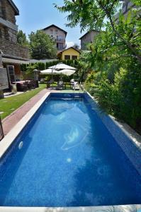 a large blue swimming pool in a yard at Villa Vuchev in Velingrad
