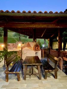 un tavolo da picnic e panche davanti a un forno per pizza di CASA DEL CANTA a Borgomale