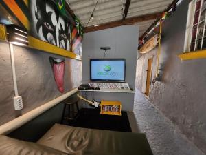 a room with a computer on a desk with a mural at Vila Rock Hostel - próximo Allianz Parque, Vila Madalena, Av Paulista, Hospital das Clínicas INCOR FMUSP in São Paulo