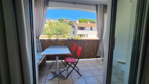 a table and two chairs on a balcony with a view at Appart T3, quartier calme , idéal tout à pieds parking privé Résidence Cadenisse in Collioure +3 photos