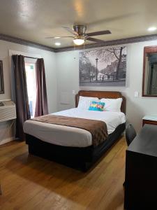 德里平斯普林斯Outpost Motel的带床和吊扇的卧室
