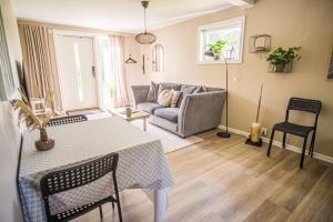 a living room with a table and a couch at Hallonet in Alingsås